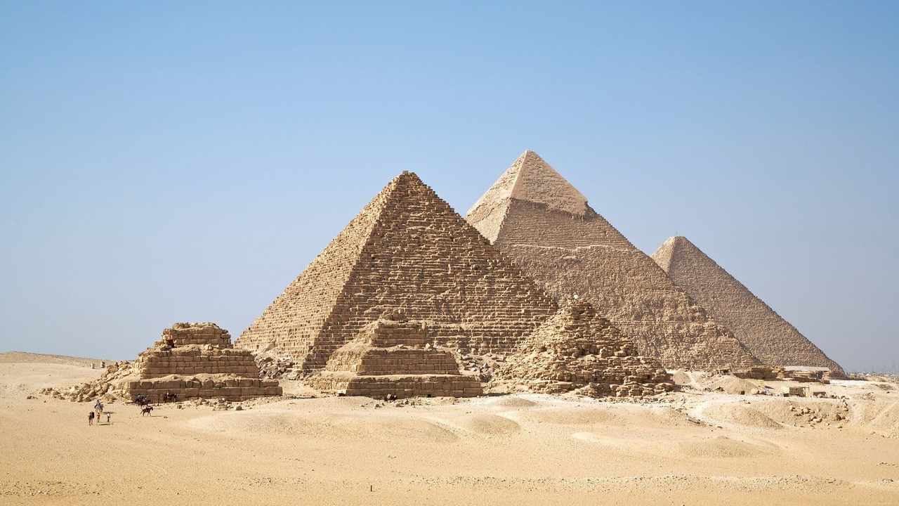 The three Pyramids of Giza in a single view across the desert plateau — Cairo trip cost guide