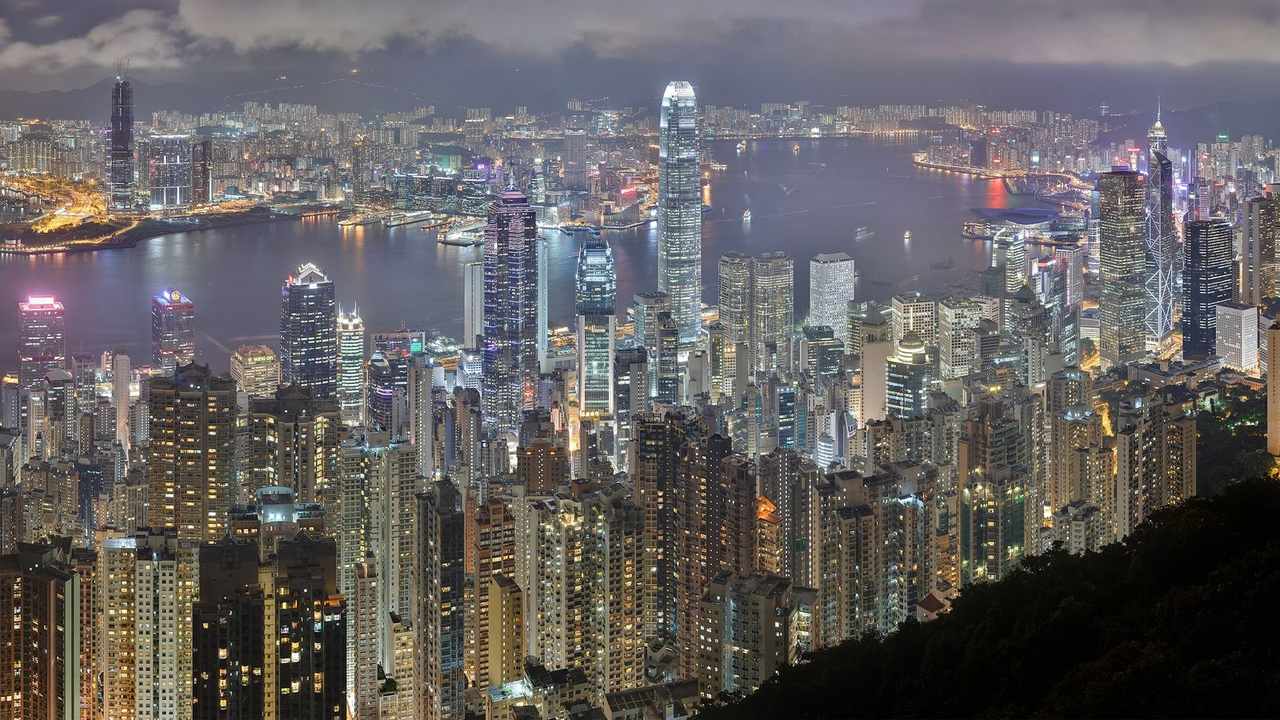 Hong Kong night skyline and Victoria Harbour panorama seen from Lugard Road on Victoria Peak, city lights reflecting across the harbour